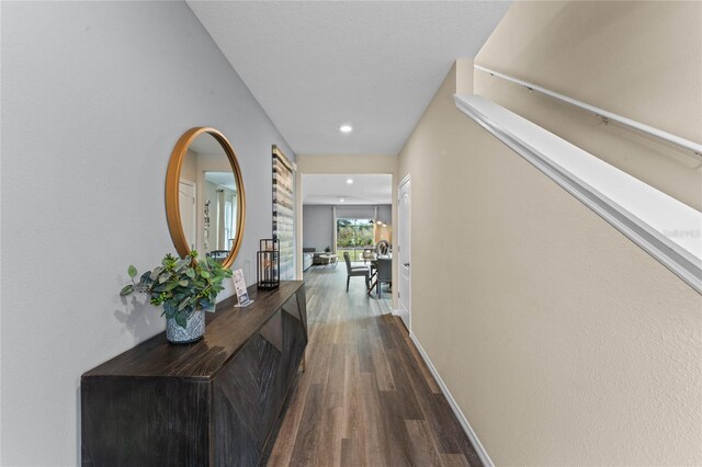 corridor featuring baseboards, recessed lighting, and dark wood finished floors