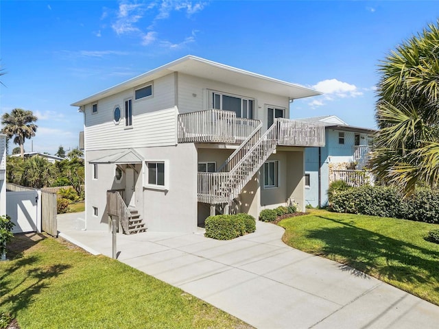 exterior space with stucco siding, fence, stairs, and a front lawn