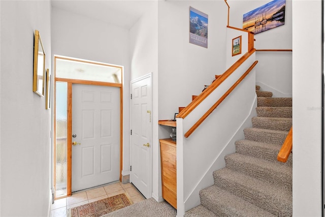 foyer featuring light tile patterned flooring and stairway