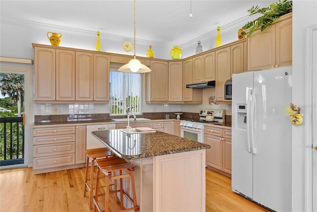 kitchen featuring a kitchen island, decorative light fixtures, crown molding, light brown cabinets, and white appliances