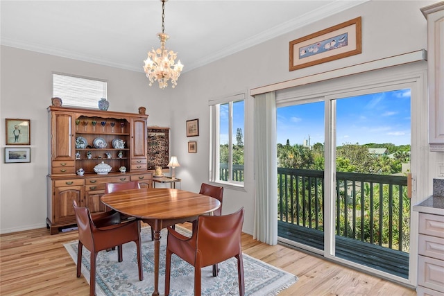 dining space with baseboards, ornamental molding, light wood-style flooring, and a notable chandelier