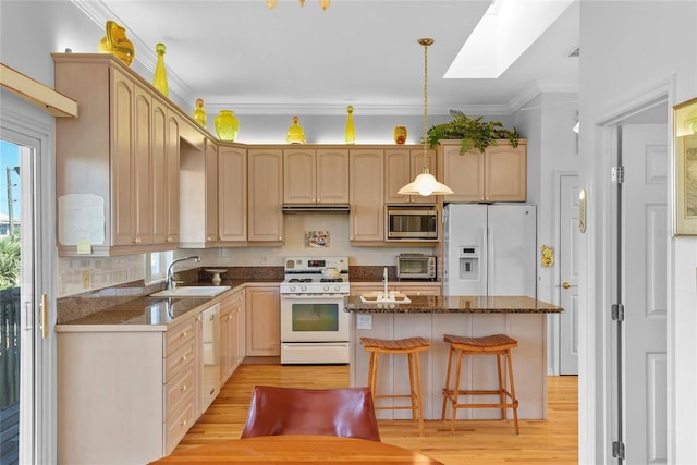 kitchen featuring a sink, light wood finished floors, white appliances, a toaster, and a kitchen island