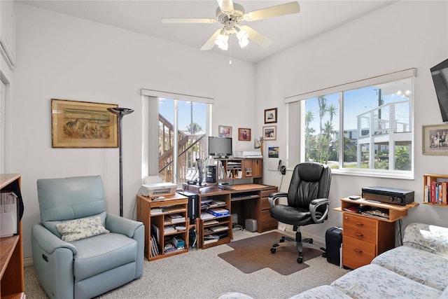 carpeted home office with ceiling fan and a wealth of natural light
