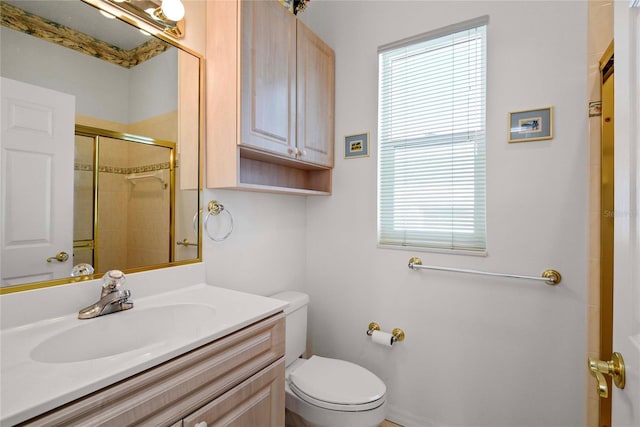 bathroom featuring vanity, a healthy amount of sunlight, a tile shower, and toilet