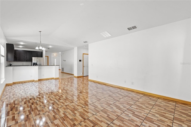 3345 Reedy Glen Dr, Kissimmee, FL 34758 - unfurnished living room with visible vents, vaulted ceiling, light tile patterned floors, baseboards, and an inviting chandelier