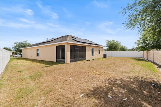 3345 Reedy Glen Dr, Kissimmee, FL 34758 - rear view of property with solar panels, a sunroom, a fenced backyard, a yard, and stucco siding