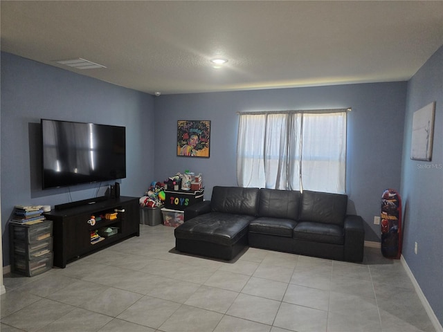 living room with visible vents, baseboards, and light tile patterned floors