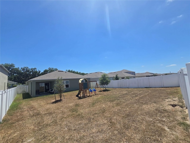 view of yard with a fenced backyard and a playground