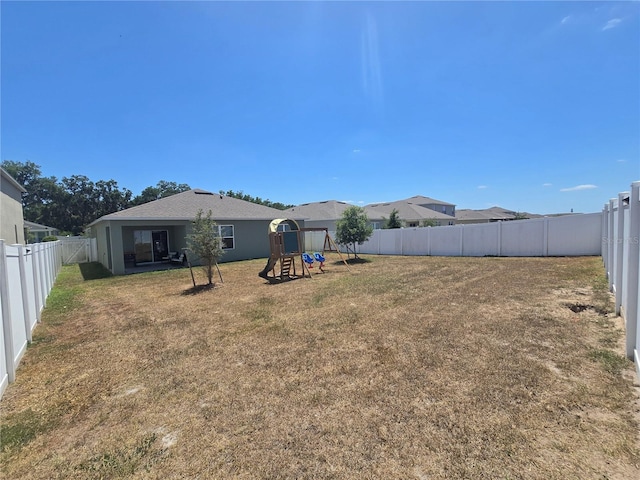 view of yard featuring a fenced backyard and a playground
