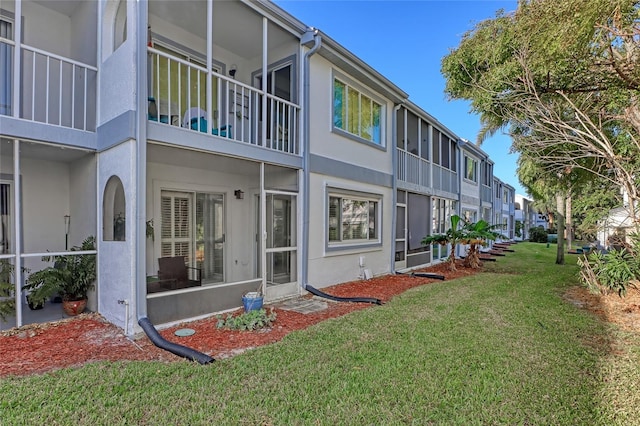 136 Beach Park Ln Unit 35, Cape Canaveral, FL 32920 - rear view of property featuring stucco siding, a yard, and a residential view