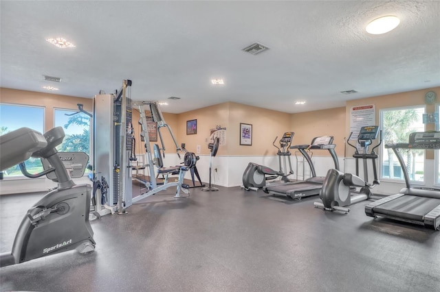 136 Beach Park Ln Unit 35, Cape Canaveral, FL 32920 - exercise room with a textured ceiling and baseboards