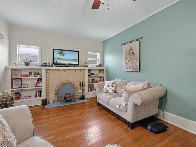 16 E Orange St, Davenport, FL 33837 - living area with ceiling fan, a fireplace with flush hearth, ornamental molding, and hardwood / wood-style flooring