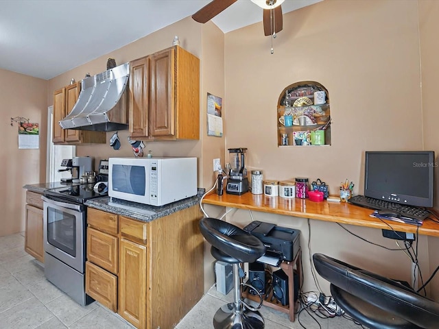 16 E Orange St, Davenport, FL 33837 - kitchen featuring ceiling fan, range hood, light tile patterned floors, white microwave, and stainless steel electric stove