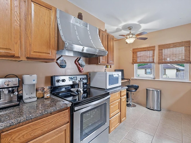 16 E Orange St, Davenport, FL 33837 - kitchen featuring a ceiling fan, light tile patterned floors, white microwave, electric stove, and extractor fan