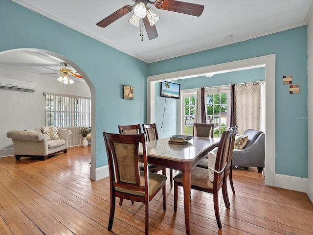 16 E Orange St, Davenport, FL 33837 - dining area featuring baseboards, a wall mounted air conditioner, ceiling fan, light wood-type flooring, and arched walkways