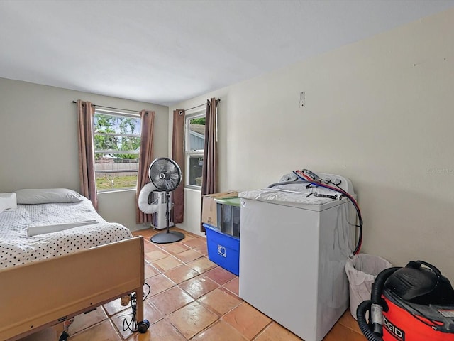 16 E Orange St, Davenport, FL 33837 - bedroom featuring washer / dryer and light tile patterned flooring