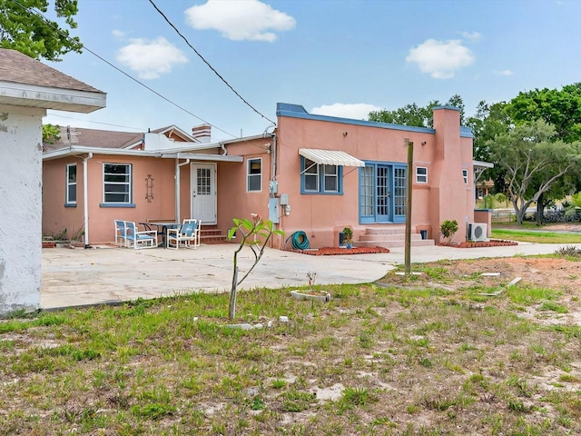 16 E Orange St, Davenport, FL 33837 - back of property featuring entry steps, stucco siding, and a patio area