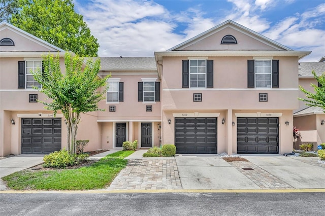 5102 Monticello Heights Ln, Oviedo, FL 32765 - townhome / multi-family property featuring stucco siding, driveway, and a garage