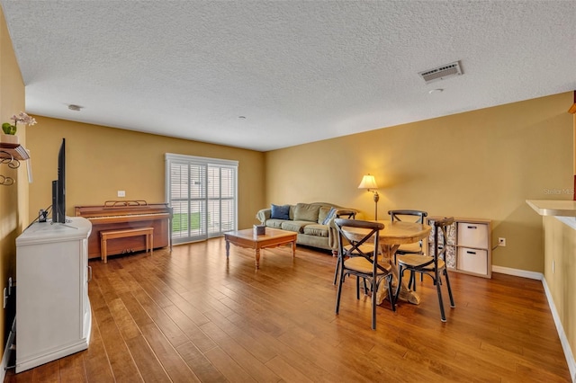 5102 Monticello Heights Ln, Oviedo, FL 32765 - dining area with a textured ceiling, wood finished floors, and baseboards