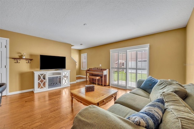 5102 Monticello Heights Ln, Oviedo, FL 32765 - living area featuring light wood-style flooring, a textured ceiling, and baseboards