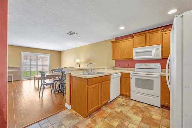 5102 Monticello Heights Ln, Oviedo, FL 32765 - kitchen featuring white appliances, a peninsula, a sink, a textured ceiling, and light countertops