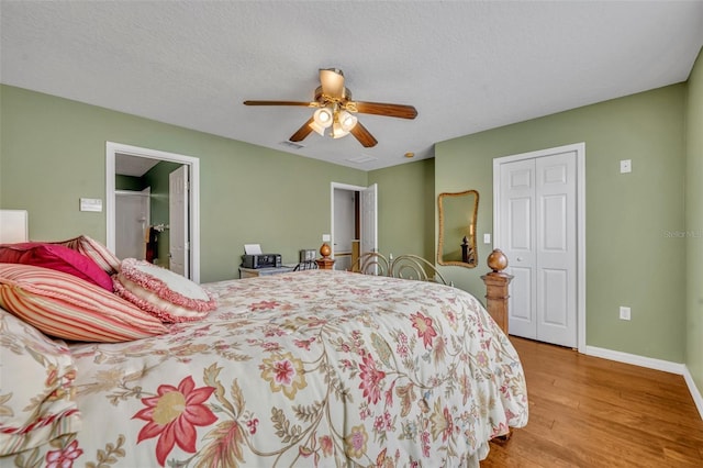 5102 Monticello Heights Ln, Oviedo, FL 32765 - bedroom featuring wood finished floors, baseboards, a closet, ceiling fan, and a textured ceiling