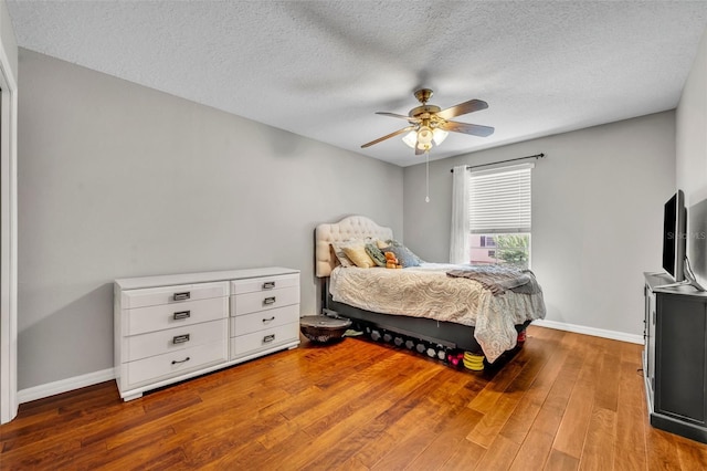 5102 Monticello Heights Ln, Oviedo, FL 32765 - bedroom with wood finished floors, baseboards, a textured ceiling, and a ceiling fan