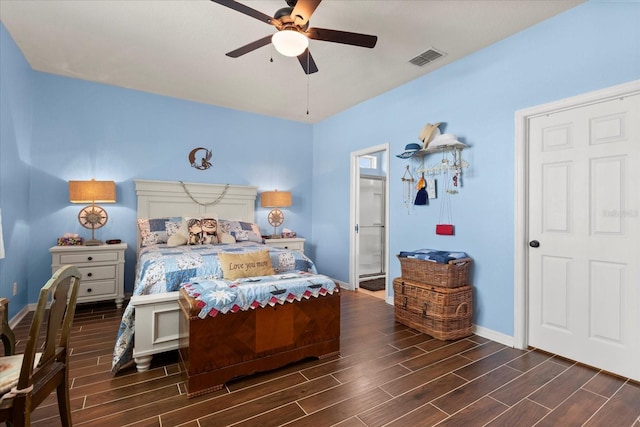 bedroom featuring wood tiled floor, a ceiling fan, visible vents, baseboards, and ensuite bath