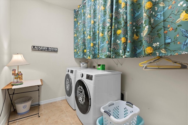 clothes washing area with laundry area, baseboards, tile patterned flooring, and washer and dryer