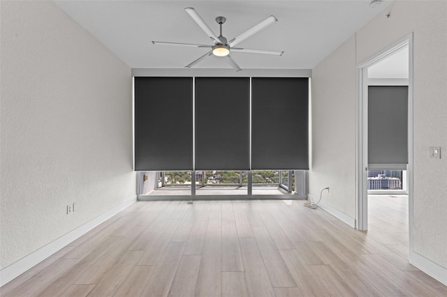 spare room with a ceiling fan, a textured wall, and wood finished floors