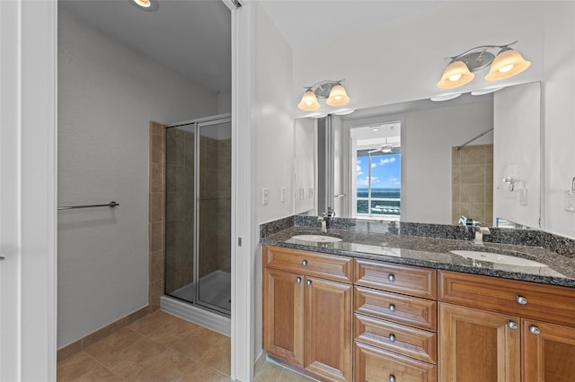 full bathroom featuring double vanity, baseboards, a sink, and a stall shower