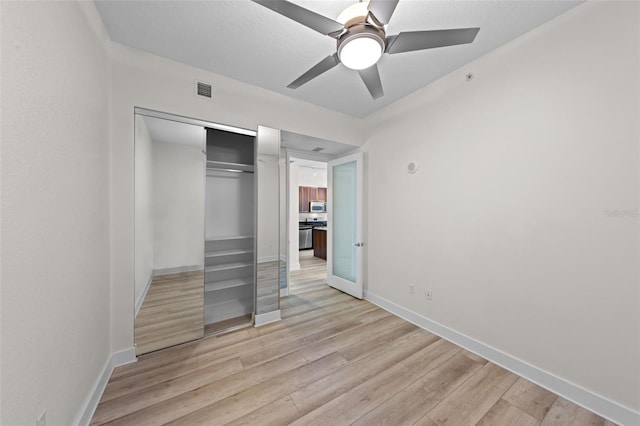 unfurnished bedroom with visible vents, a closet, light wood-style floors, baseboards, and ceiling fan