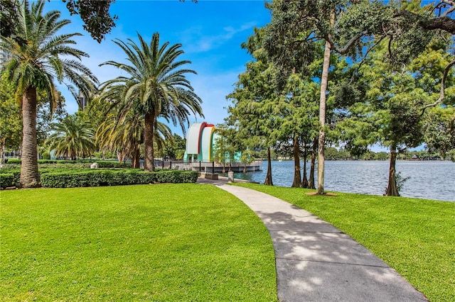view of home's community with a water view and a yard