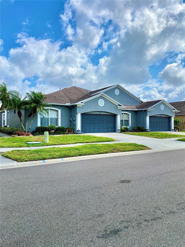30442 Lettingwell Cir, Wesley Chapel, FL 33543 - view of front of house featuring stucco siding, driveway, a front yard, and a garage