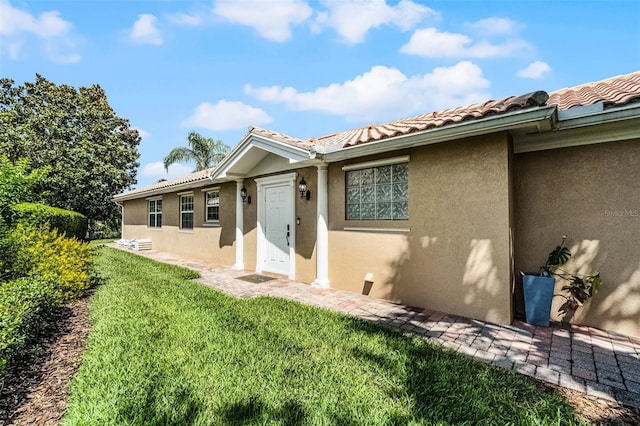 11908 Delfina Ln, Orlando, FL 32827 - property entrance featuring a yard, a tile roof, and stucco siding