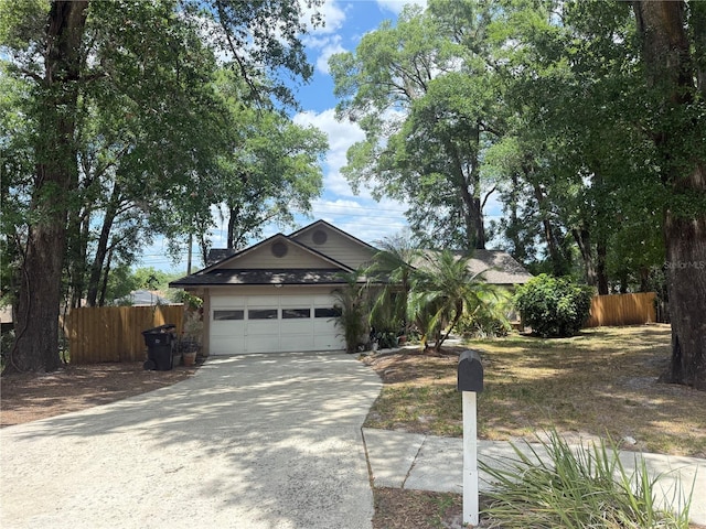 view of front of home with an attached garage, fence, and concrete driveway