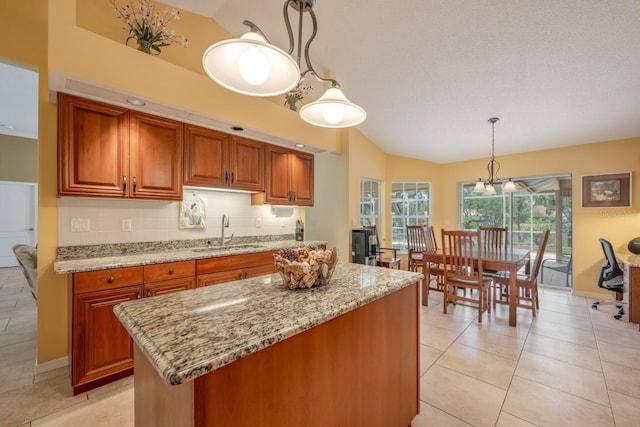 8202 Shadow Pine Way, Sarasota, FL 34238 - kitchen featuring a sink, lofted ceiling, light stone countertops, brown cabinets, and light tile patterned floors