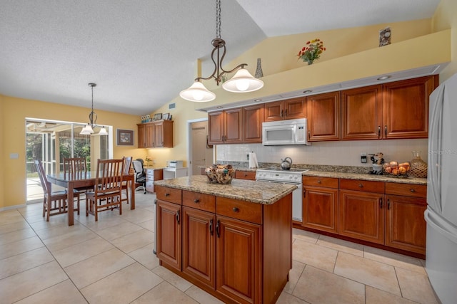 8202 Shadow Pine Way, Sarasota, FL 34238 - kitchen featuring white appliances, vaulted ceiling, brown cabinets, a kitchen island, and light stone counters