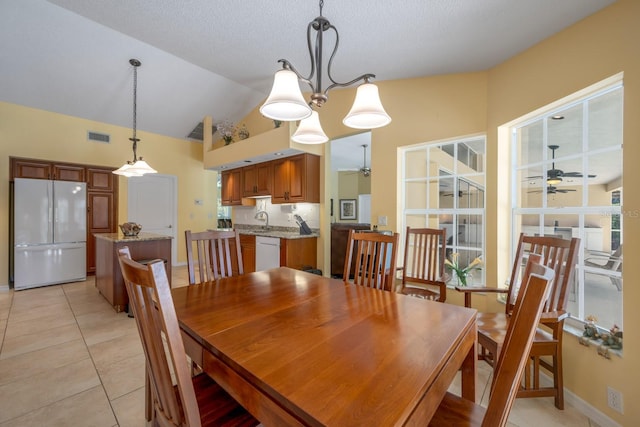 8202 Shadow Pine Way, Sarasota, FL 34238 - dining space featuring a ceiling fan, vaulted ceiling, light tile patterned flooring, and baseboards
