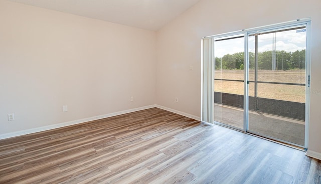 empty room with baseboards, wood finished floors, and lofted ceiling