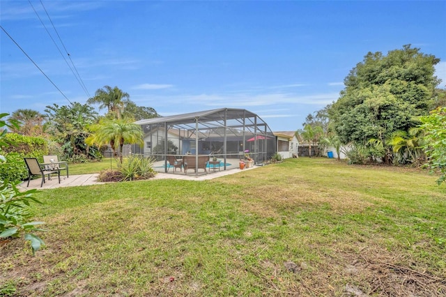 view of yard featuring glass enclosure, a patio area, an outdoor pool, and fence