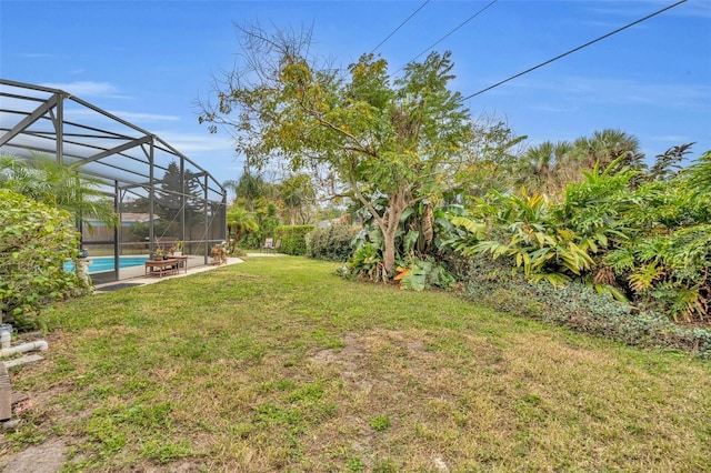 view of yard featuring glass enclosure and an outdoor pool