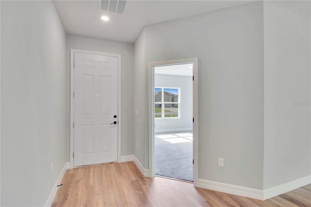 doorway to outside featuring baseboards, visible vents, and light wood-type flooring