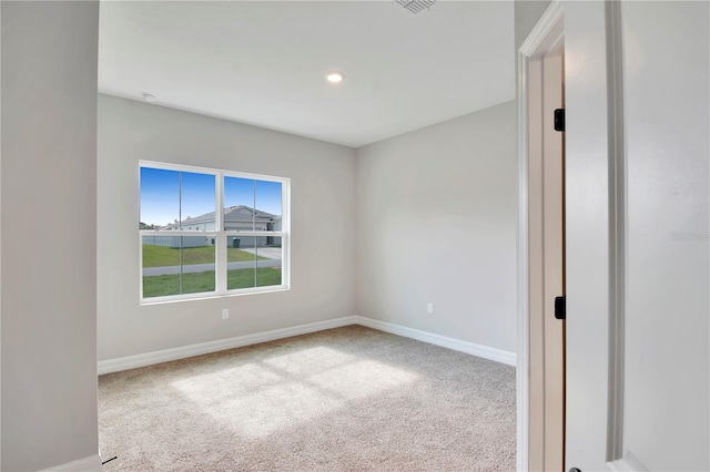 carpeted spare room featuring baseboards