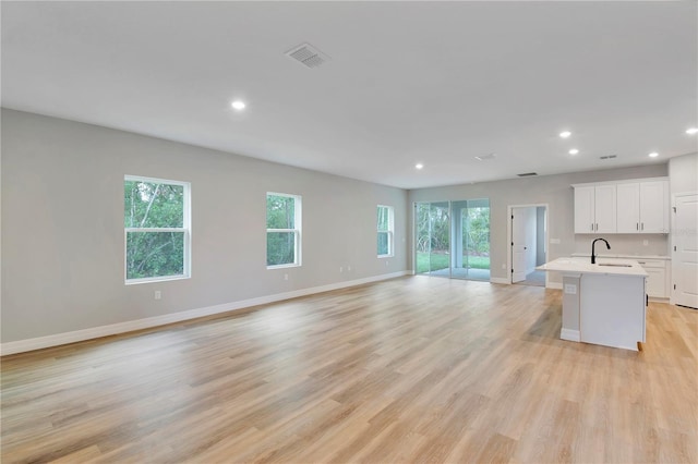 interior space featuring visible vents, open floor plan, recessed lighting, light countertops, and a sink