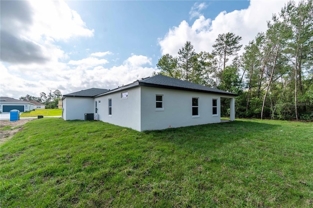 view of side of property with a lawn, stucco siding, and cooling unit