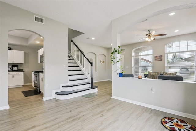 29704 Eagle Station Dr, Wesley Chapel, FL 33543 - entryway with a ceiling fan, light wood-style flooring, baseboards, stairway, and arched walkways