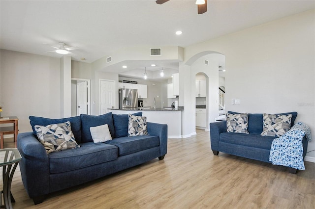 29704 Eagle Station Dr, Wesley Chapel, FL 33543 - living room featuring light wood finished floors, arched walkways, a ceiling fan, and visible vents