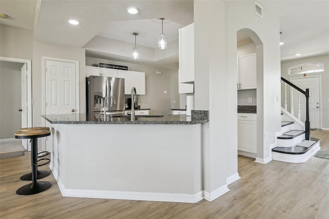 29704 Eagle Station Dr, Wesley Chapel, FL 33543 - kitchen with light wood-style floors, stainless steel fridge, and dark stone counters