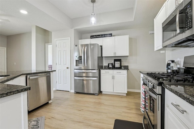 29704 Eagle Station Dr, Wesley Chapel, FL 33543 - kitchen featuring stainless steel appliances, light wood-style flooring, white cabinetry, baseboards, and hanging light fixtures